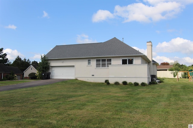 view of front of house with a front lawn, a playground, and a garage