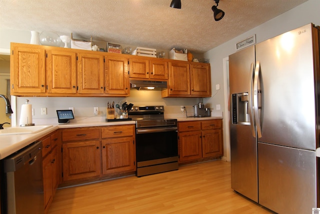 kitchen with dishwasher, stainless steel refrigerator with ice dispenser, light hardwood / wood-style floors, electric range, and sink