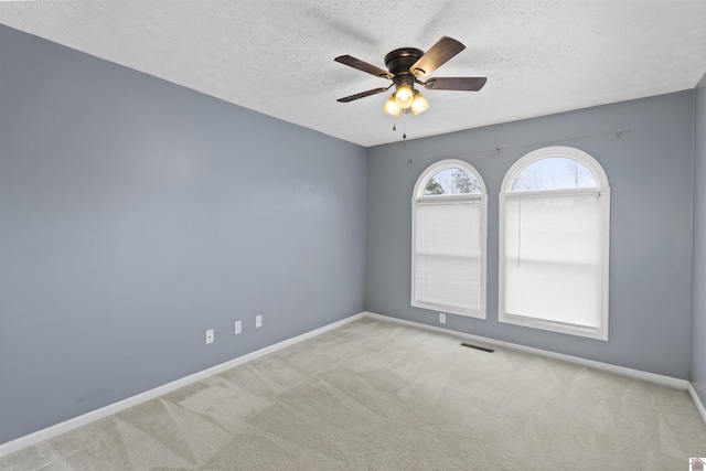 carpeted spare room featuring a textured ceiling and ceiling fan