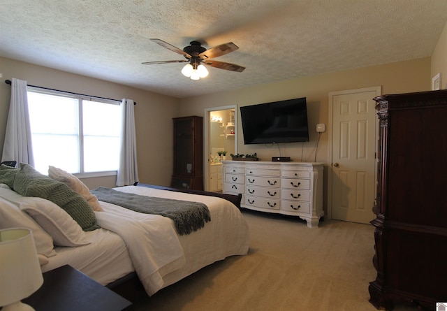 carpeted bedroom with ensuite bath, a textured ceiling, and ceiling fan