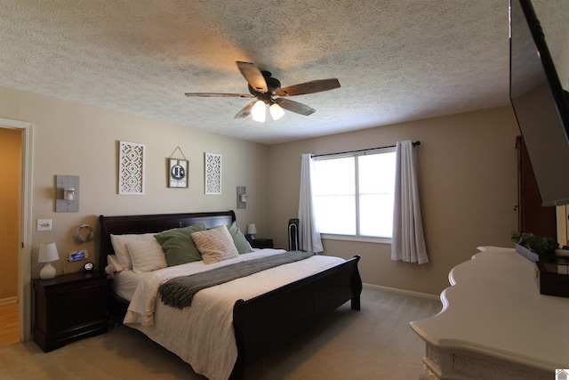 carpeted bedroom featuring ceiling fan and a textured ceiling