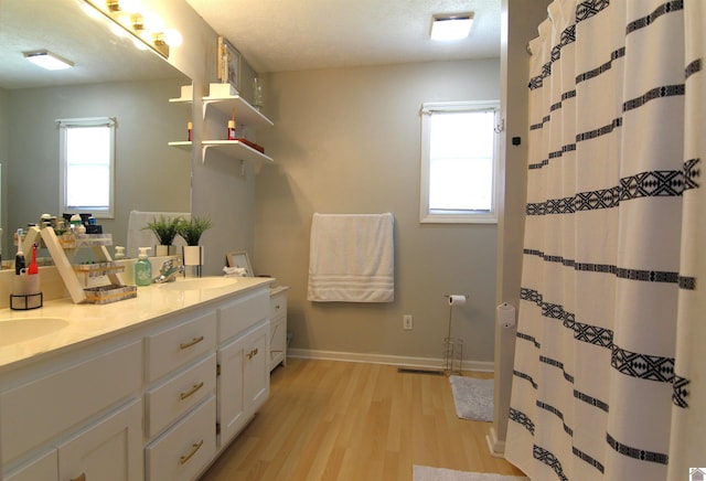 bathroom with double vanity, a textured ceiling, and hardwood / wood-style floors