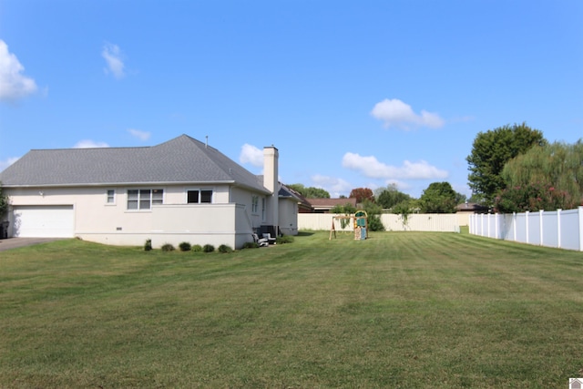 exterior space with a playground, a yard, and a garage