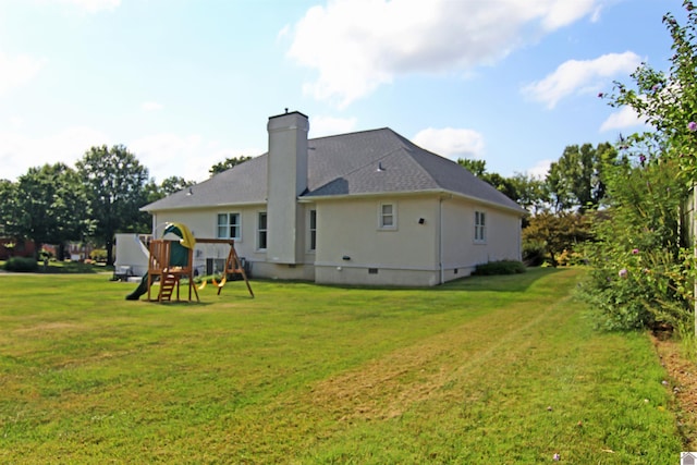 rear view of house featuring a playground and a yard