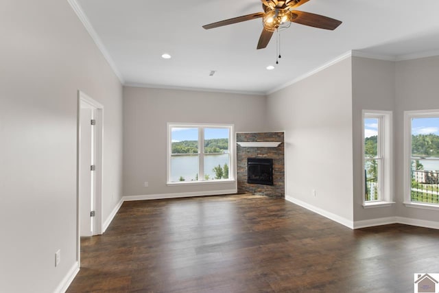 unfurnished living room with a stone fireplace, plenty of natural light, ceiling fan, and dark hardwood / wood-style flooring