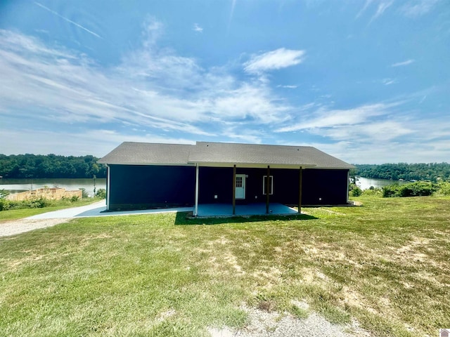 view of outdoor structure featuring a lawn and a water view