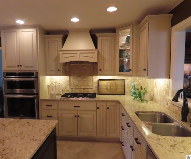 kitchen featuring stainless steel double oven, light tile patterned floors, backsplash, premium range hood, and black gas stovetop