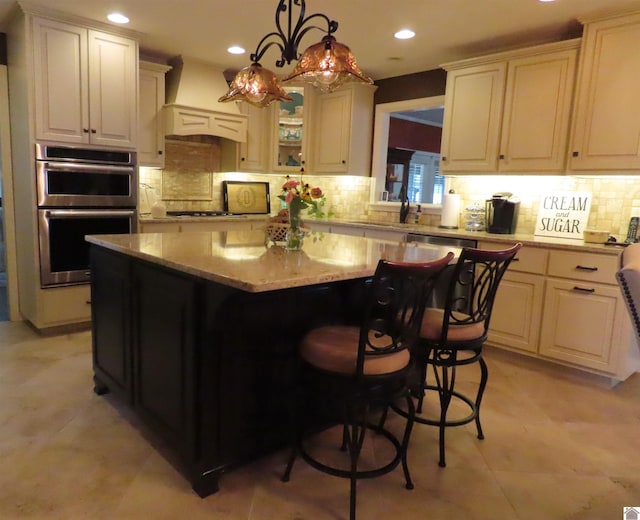 kitchen featuring pendant lighting, light tile patterned flooring, stainless steel appliances, premium range hood, and a kitchen island