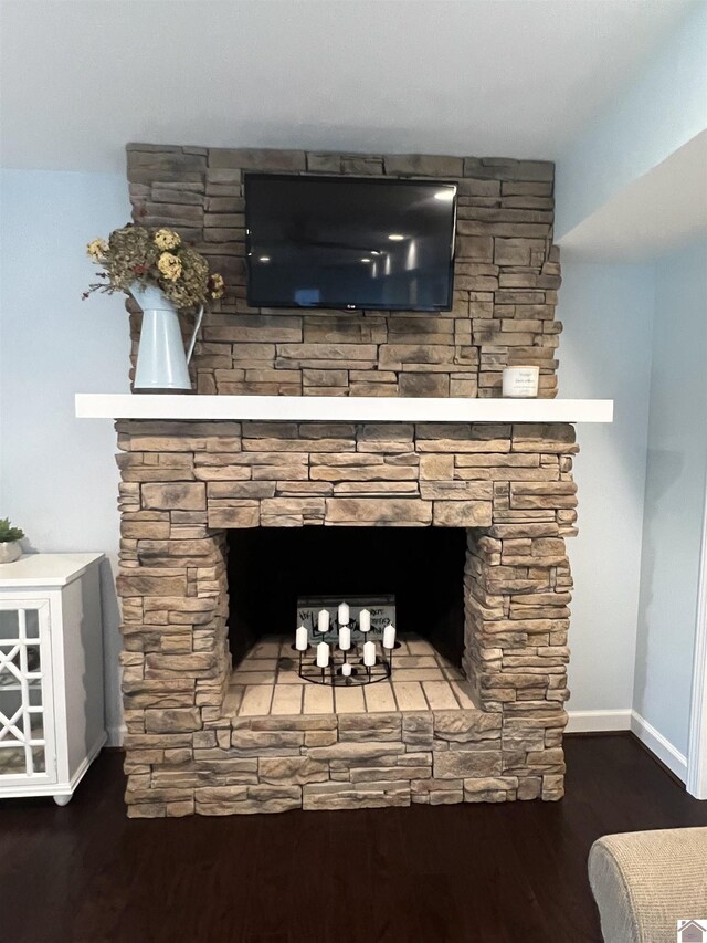 room details featuring wood-type flooring and a stone fireplace