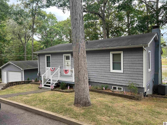 view of front of house with an outbuilding, central AC unit, a front lawn, and a garage