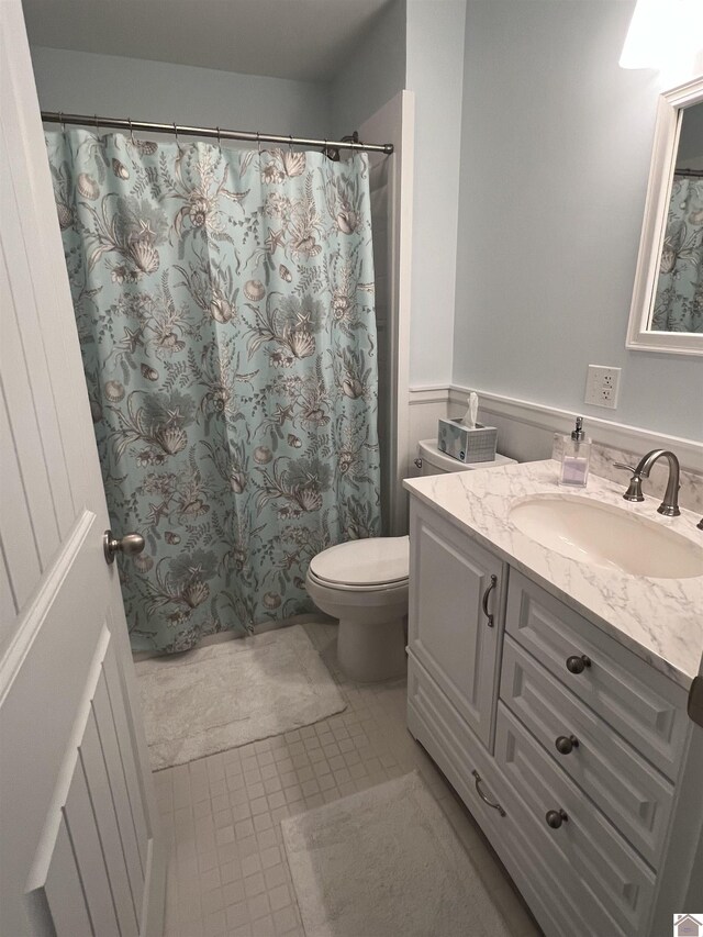 bathroom with toilet, tile patterned floors, and vanity