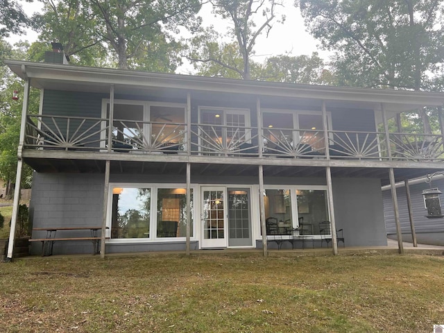 back of house with a balcony and a lawn