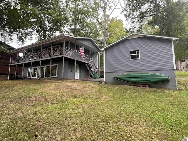 back of property featuring a wooden deck and a lawn