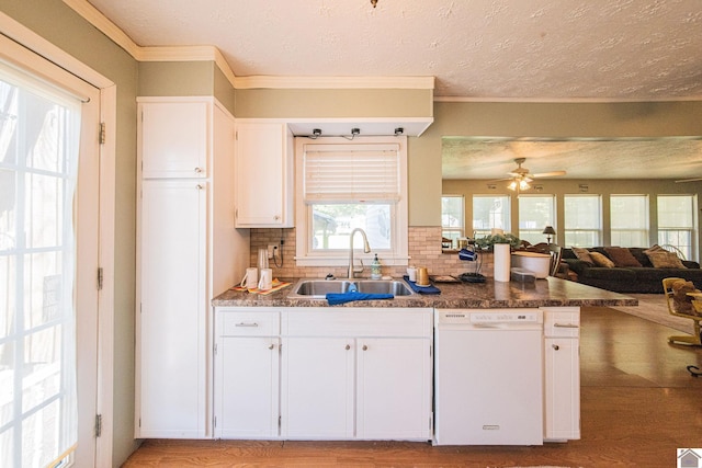 kitchen featuring a sink, open floor plan, white cabinets, white dishwasher, and decorative backsplash