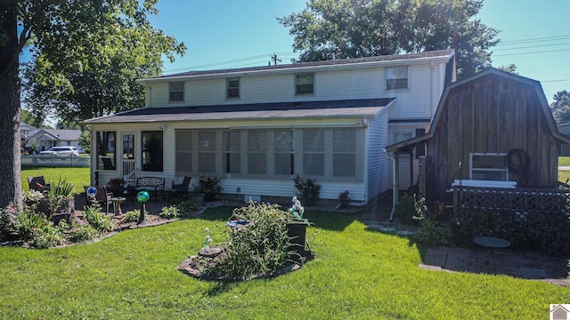 rear view of house with a yard, a patio, and a sunroom