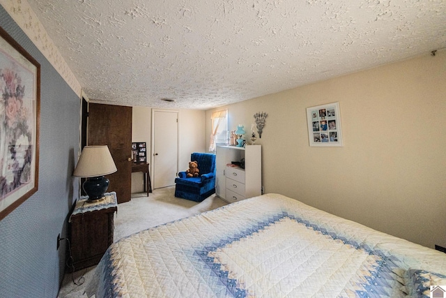 bedroom with light carpet and a textured ceiling