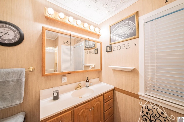 bathroom featuring vanity, wallpapered walls, crown molding, and walk in shower