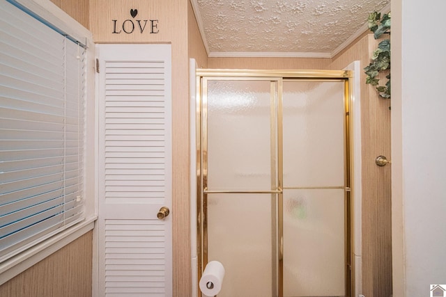 full bath with crown molding, a stall shower, and a textured ceiling