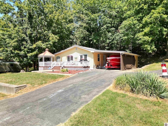 ranch-style home featuring a front lawn and a carport