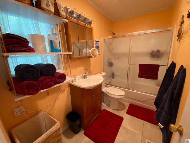 full bathroom with shower / bath combination with glass door, tile patterned flooring, toilet, and vanity