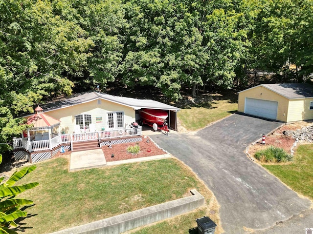 view of front of house featuring a front lawn, an outdoor structure, a garage, and a deck