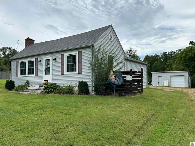 view of front of house with a front lawn, an outdoor structure, and a garage