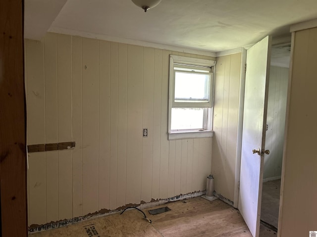 interior space featuring light wood-type flooring and wood walls