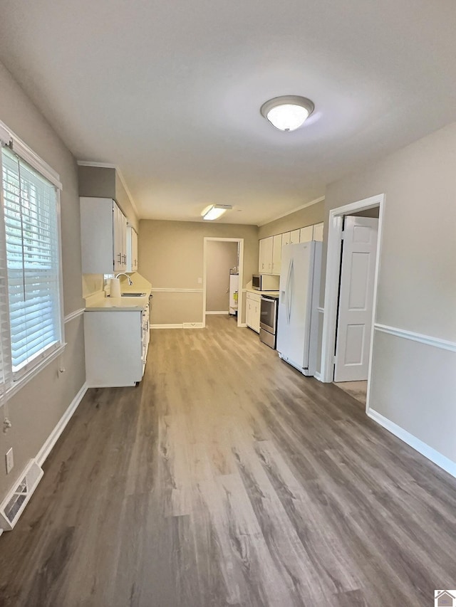 kitchen with sink, fridge, white cabinets, white refrigerator with ice dispenser, and hardwood / wood-style flooring