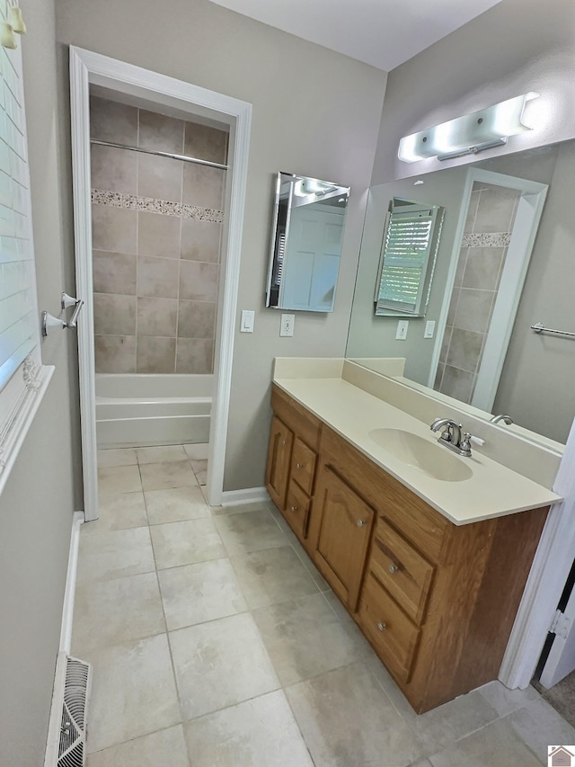 bathroom featuring tile patterned flooring, vanity, and tiled shower / bath combo