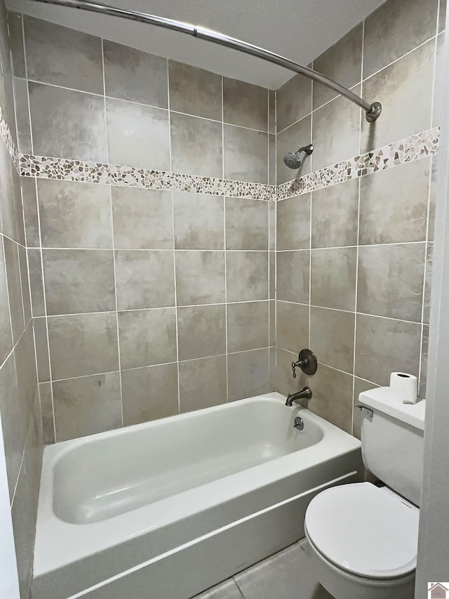 bathroom with toilet and tiled shower / bath combo