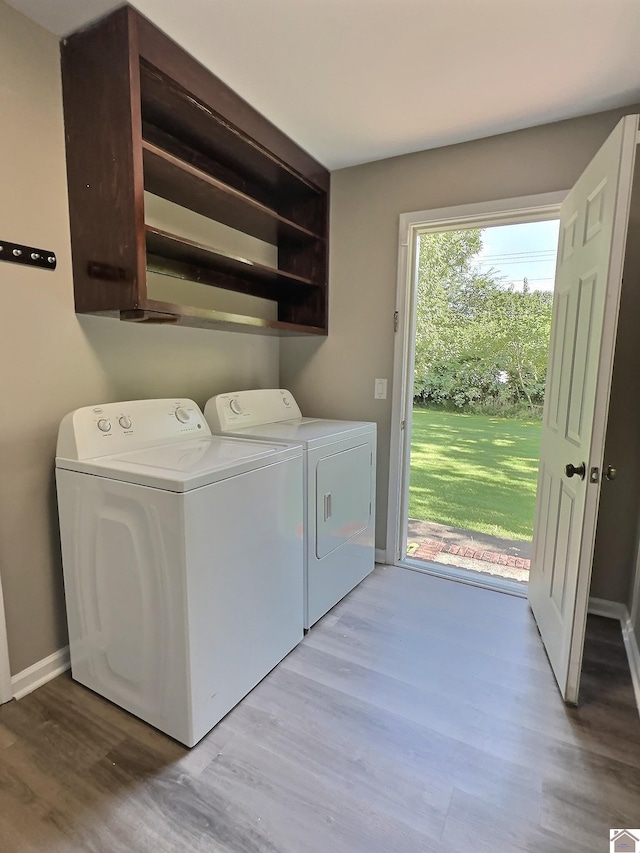 laundry room with washer and dryer, cabinets, and wood-type flooring