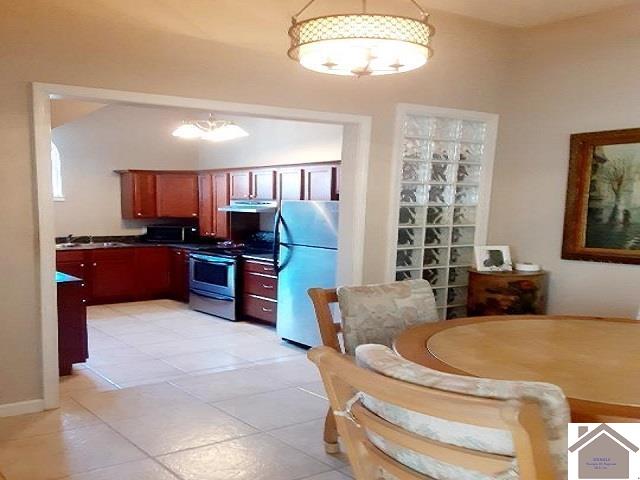 kitchen with light tile patterned flooring, appliances with stainless steel finishes, and sink