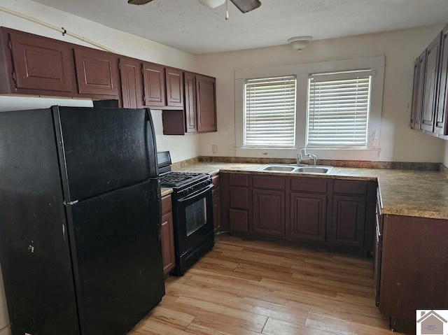 kitchen with a textured ceiling, light wood-style flooring, a sink, a ceiling fan, and black appliances