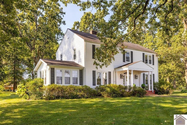 view of front of house with a chimney and a front lawn