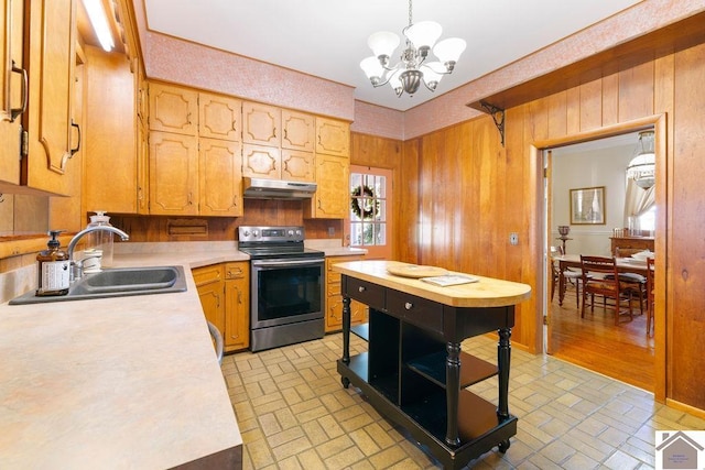 kitchen featuring a sink, stainless steel electric range oven, under cabinet range hood, and brick patterned floor