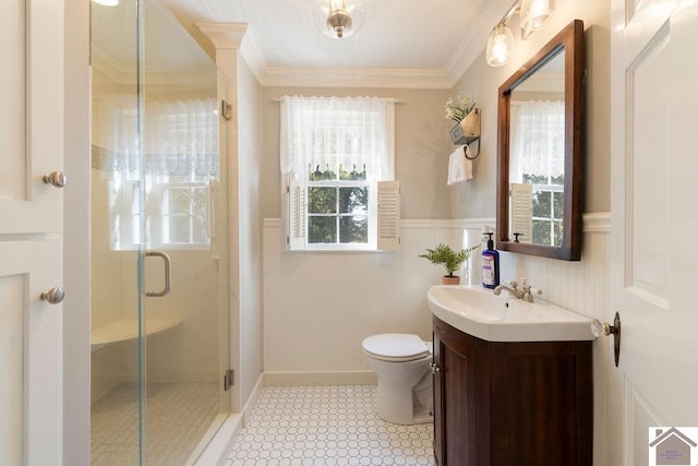 bathroom with vanity, ornamental molding, toilet, a wainscoted wall, and a stall shower