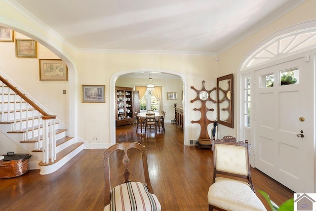 entryway with ornamental molding, dark hardwood / wood-style flooring, and a healthy amount of sunlight