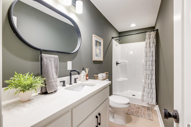 bathroom with vanity, hardwood / wood-style flooring, toilet, and walk in shower