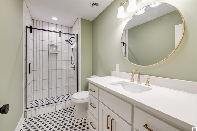 bathroom featuring a tile shower, vanity, toilet, and tile patterned floors