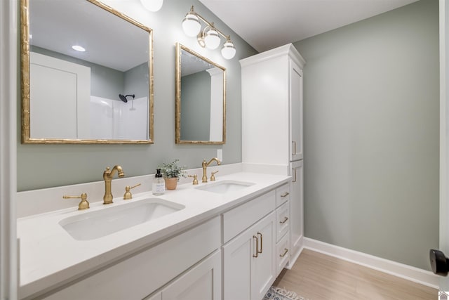 bathroom featuring hardwood / wood-style floors, vanity, and a shower