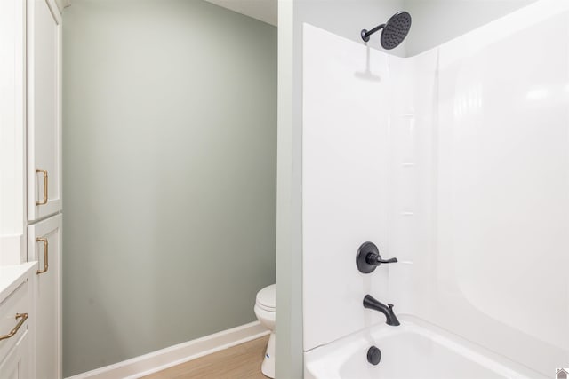 full bathroom featuring hardwood / wood-style flooring, vanity,  shower combination, and toilet