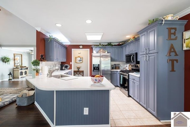 kitchen featuring appliances with stainless steel finishes, crown molding, a breakfast bar, kitchen peninsula, and light tile patterned flooring