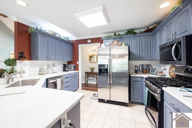 kitchen featuring light tile patterned flooring, crown molding, stainless steel appliances, and sink