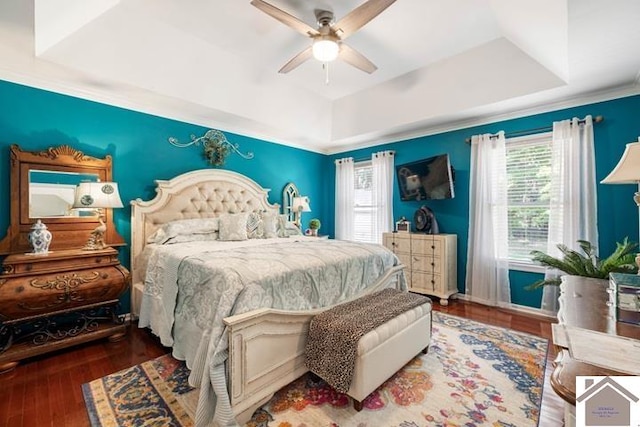 bedroom with ceiling fan, hardwood / wood-style floors, and a tray ceiling