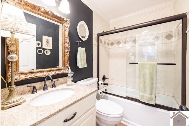 full bathroom featuring crown molding, toilet, vanity, and bath / shower combo with glass door