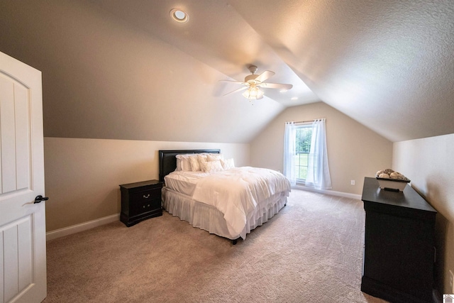 bedroom featuring ceiling fan, lofted ceiling, a textured ceiling, and light colored carpet