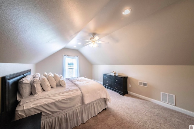 carpeted bedroom with ceiling fan, lofted ceiling, and a textured ceiling