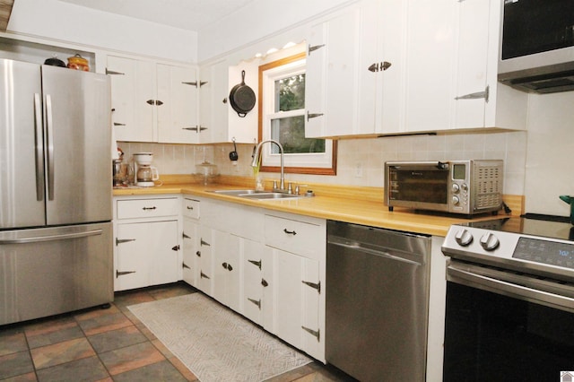 kitchen featuring sink, white cabinetry, backsplash, and stainless steel appliances