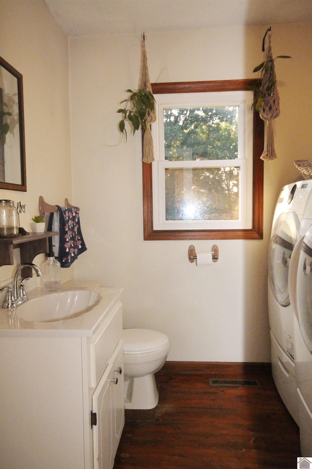 bathroom with separate washer and dryer, hardwood / wood-style flooring, toilet, and vanity