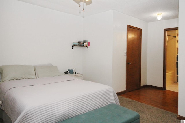 bedroom with connected bathroom and dark wood-type flooring